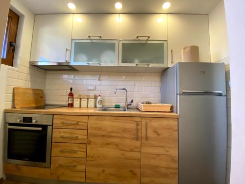 コパオニクにあるCasa Nostra Kopのキッチン(木製キャビネット、冷蔵庫付)