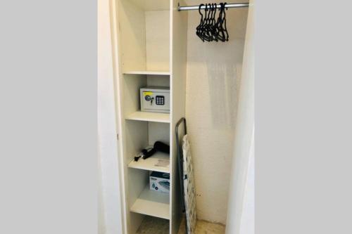 a closet with white shelves in a room at Charmant studio avec terrasse vue mer à 50 m in Sainte-Maxime