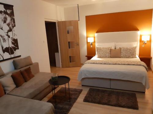 - une chambre avec un grand lit et un canapé dans l'établissement Apartmán Hanka, à Znojmo