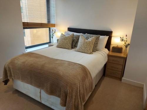 um quarto com uma cama grande e uma janela em City 2 Bed, 2 Bath, Free Parking & WiFi em Sheffield