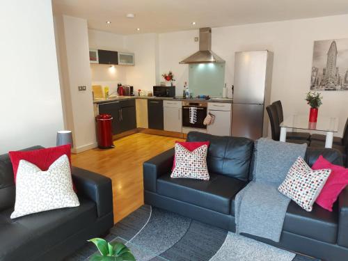 a living room with two couches and a kitchen at City 2 Bed, 2 Bath, Free Parking & WiFi in Sheffield