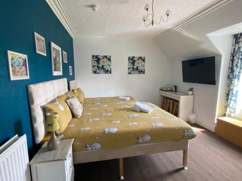 a bedroom with a bed with a yellow comforter at No 29 Bed and Breakfast in Inverness