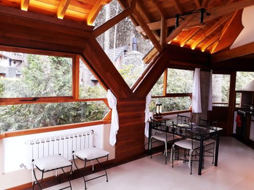 a room with a table and chairs and windows at Casas Juanjo in Mar de las Pampas