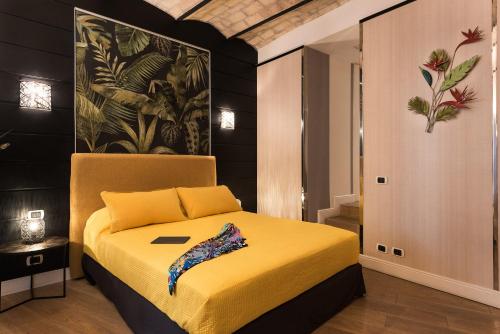 a bedroom with a bed with a yellow bedspread at Idyllia - Colosseum luxury apartment in Rome