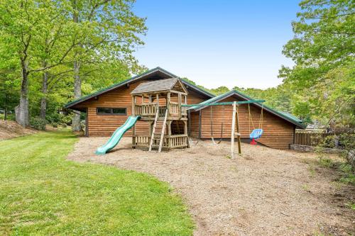 a house with a playground with a slide at Highland Haven in Newland