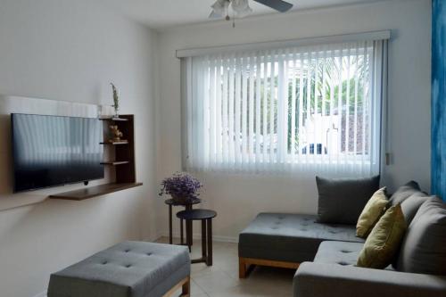a living room with a couch and a tv at Rincón de Luz Cuernavaca in Cuernavaca