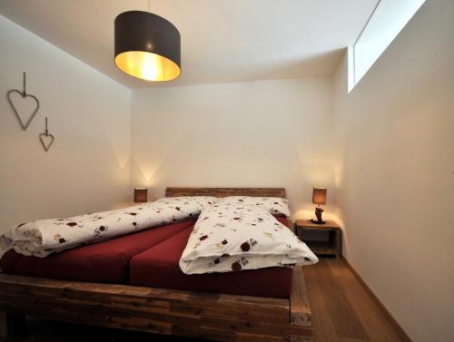a bedroom with a bed with a wooden bed frame at Rachögna in Scuol