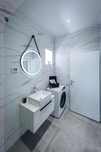 a bathroom with a washing machine and a sink at Villa Pajkan in Dubrovnik