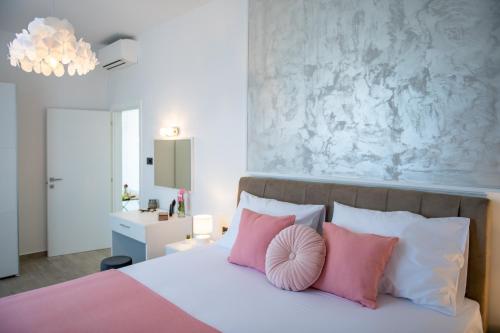 a bedroom with a bed with pink and white pillows at Villa Pajkan in Dubrovnik