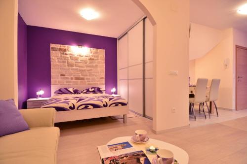 een slaapkamer met een bed met een paarse muur bij Apartment Scents of Dubrovnik in Dubrovnik