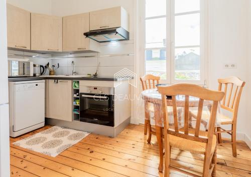une cuisine avec une table et des chaises dans une pièce dans l'établissement Appartement Les Mouettes C.L.S Deauville, à Deauville