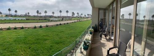 a balcony with a view of a field of grass at Bello departamento av del mar in Coquimbo