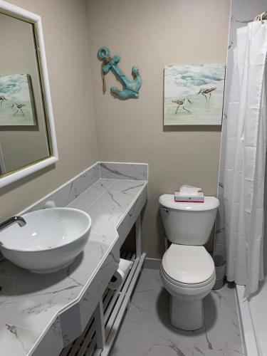 a white bathroom with a sink and a toilet at Ocean Manor 1100 Inn in Ocean City