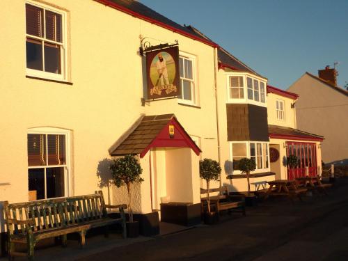a building with a clock on the side of it at The Cricket Inn in Beesands