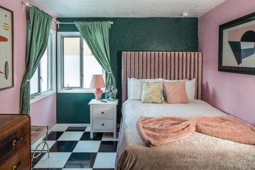 a bedroom with pink and green walls and a bed at Mid-Century Modern Home in Beautiful La Quinta in La Quinta