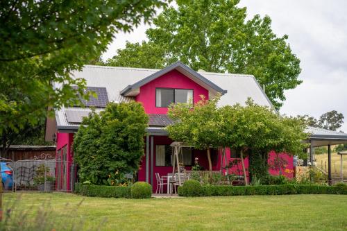 a red house with a gray roof at Magenta Cottage in Tumbarumba