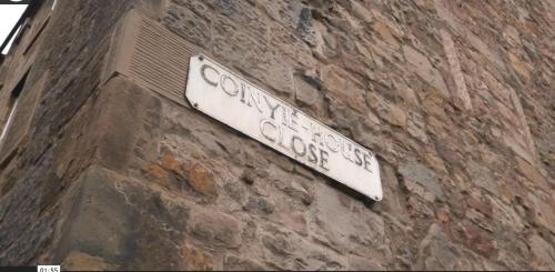 een straatbord aan de zijkant van een bakstenen gebouw bij Royal Mile Old Town Apartment in Edinburgh