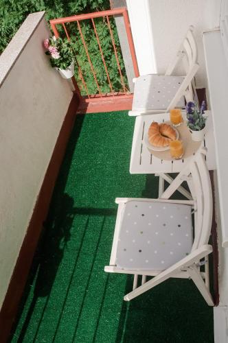 a balcony with a chair and a table with bread at Point in Sarajevo