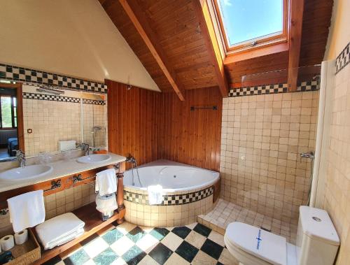 a bathroom with a tub and two sinks and a toilet at Tierras de Moya in Los Huertos