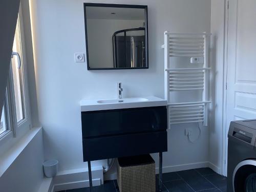 a bathroom with a sink and a mirror on the wall at Location Granville à 50m de la mer (1 à 4 pers) (neuf) in Granville