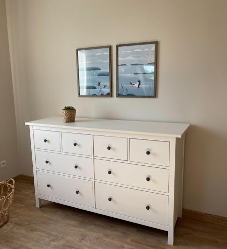 a white dresser with two windows in a room at Willa Julianna in Mikołajki