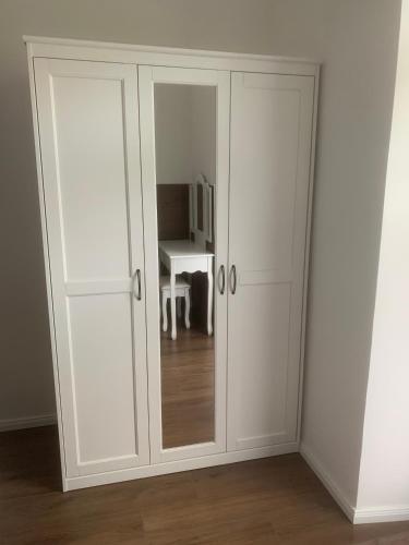 a white cabinet with a mirror in a room at Gasthof Löwen in Pfronten
