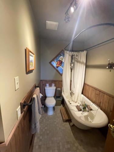 ein Badezimmer mit einer Badewanne, einem WC und einem Waschbecken in der Unterkunft Au Coeur des Jardins in Compton