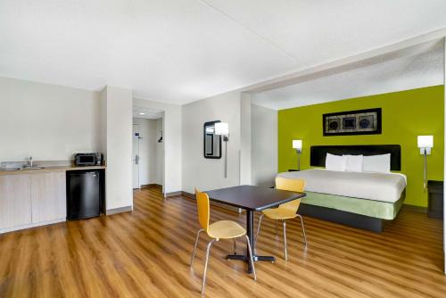 a hotel room with a bed and a table and chairs at Motel 6-Lawrenceville, NJ in Lawrenceville