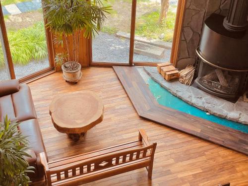 a living room with a table and a swimming pool at Nikko Akarinoyado Villa Revage in Nikko