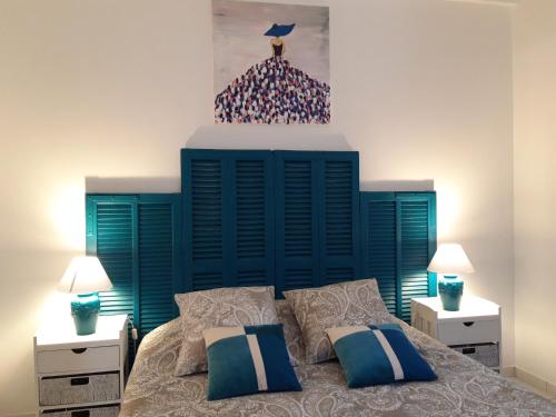a bedroom with a bed with a blue headboard and two lamps at La Margottière chez isa et titi in Rians