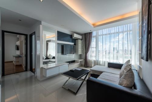 a living room with a couch and a large window at Naki Suites @ Silvertown in Phnom Penh