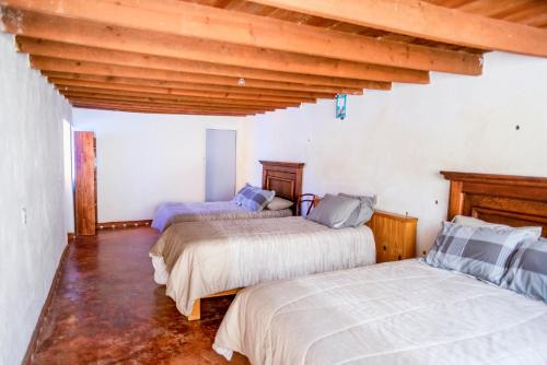 a bedroom with two beds and a wooden ceiling at Villas de Santa Ana in Manuel F. Martínez