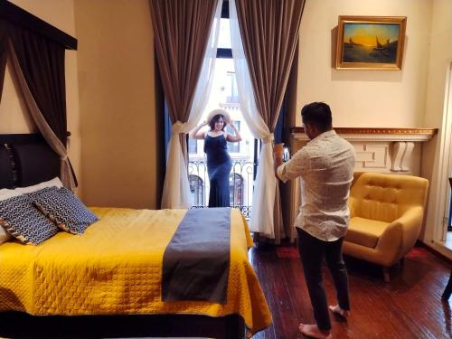 a woman looking out the window of a hotel room at Hotel Providencia - Avenida Principal, Centro Histórico de Zacatecas in Zacatecas