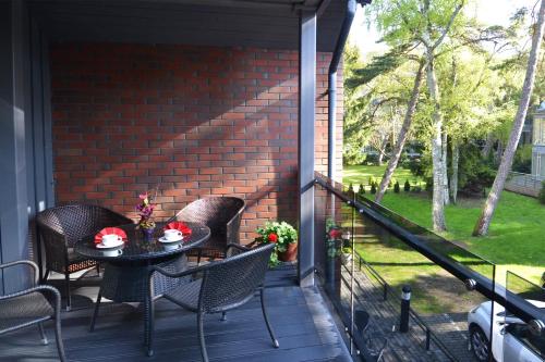 a patio with a table and chairs on a porch at Saulės Krantas in Palanga