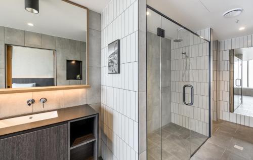 a bathroom with a glass shower and a sink at Mövenpick Hotel Hobart in Hobart