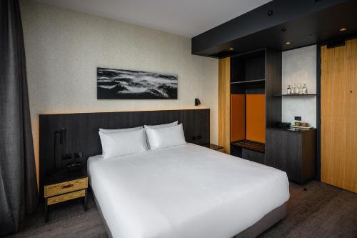a bedroom with a large white bed in a room at Mövenpick Hotel Hobart in Hobart