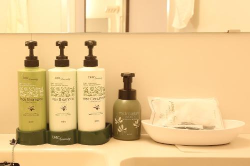a group of four shampoo bottles sitting on a sink at Sun Hotel Tosu Saga in Tosu