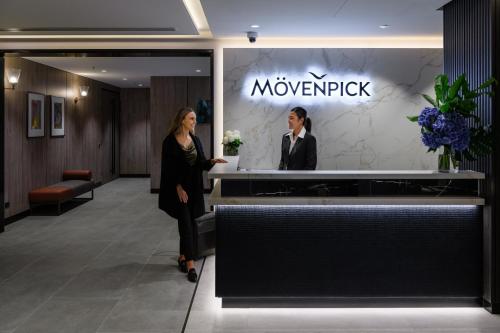 a woman standing in the lobby of a moxy hotel at Mövenpick Hotel Hobart in Hobart