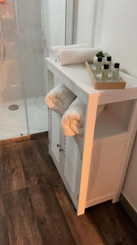 a bathroom vanity with a white counter with towels at Appartement et Garage au Cœur de l'Isle in LʼIsle-sur-la-Sorgue