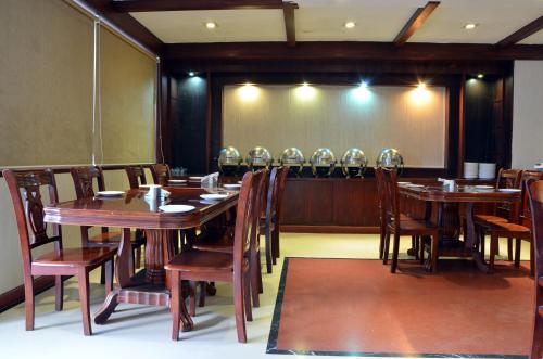 uma sala de jantar com mesas e cadeiras e um grande ecrã em Hotel Bhoomivilas em Agra