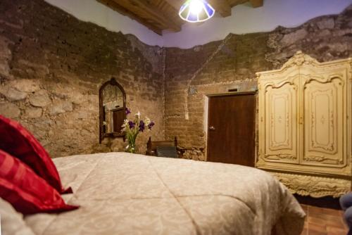 a bedroom with a bed and a stone wall at Villas de Santa Ana in Manuel F. Martínez