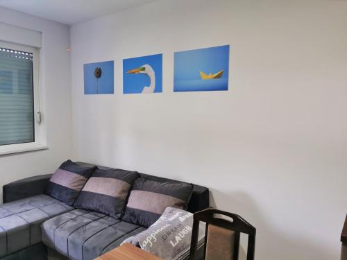a living room with a couch and pictures on the wall at Cozy Corner Apartments - Free parking & Wi-fi in Ćuprija