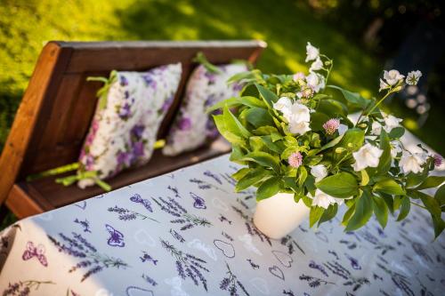 a vase filled with flowers sitting on a bed at Dom Pod Orzechem in Łapczyca