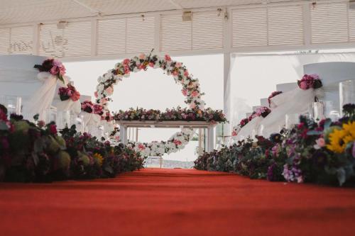 an aisle with a wedding arch and flowers at Tasia Maris Beach Hotel - Adults Only in Ayia Napa