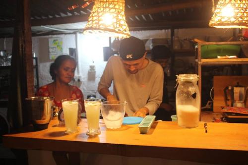 a man and a woman standing behind a table with drinks at Happy Lemon Tree lodge in Sauraha