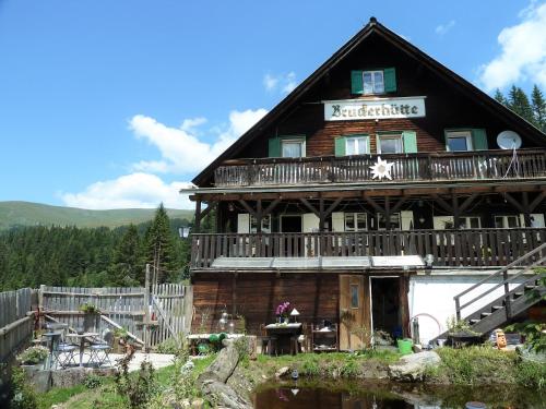 a large log cabin with a balcony on top of it at Bruckerhütte in Lachtal