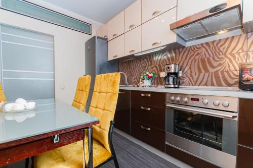 モスクワにあるLakshmi Apartment Novy Arbat 3-bedroomのキッチン(テーブル、椅子、コンロ付)