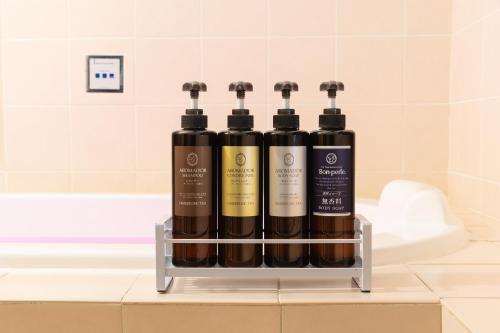 a display of four bottles of wine on a bathroom counter at ホテル ブランチャペルクリスマス 四日市 in Yokkaichi
