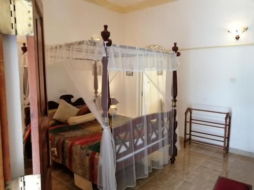 a bedroom with a bed with a canopy at Manor House-Kandy in Kandy