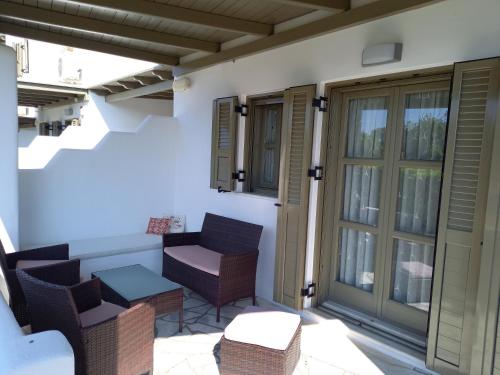a patio with chairs and a table and windows at To Pithari in Skiros